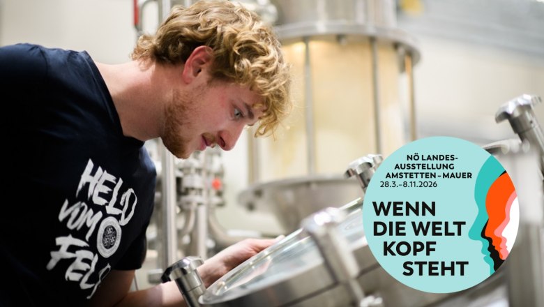 Malz Welt, © Mostviertel Tourismus/Jürgen Schmuecking Ein Mann schaut in eine Brauanlage. Ein Logo der NÖ Landesausstellung 2026 ist eingeblendet.