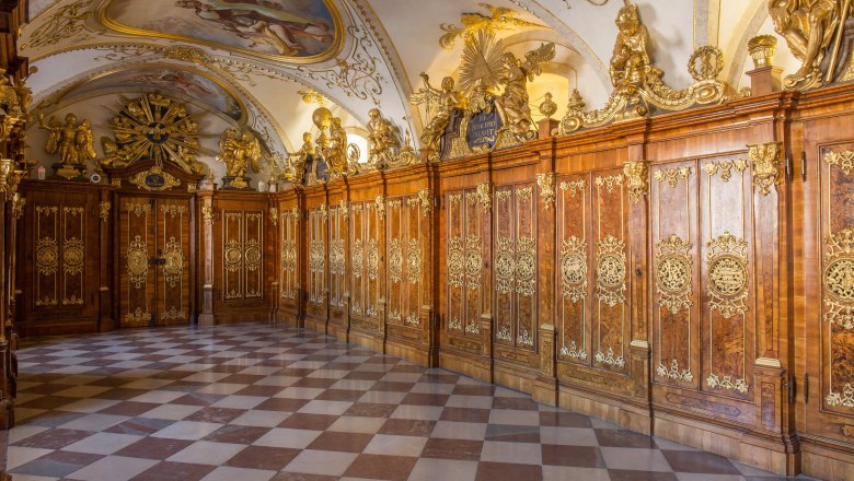 Prunkvoller Raum mit verzierten Holzpaneelen und Deckenmalerei.