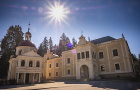 Töpperschloss Neubruck bei Sonnenschein mit blauer Himmel und Bäumen im Hintergrund.