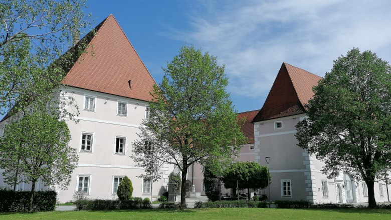 Schloss Hotel Zeillern mit gr&uuml;ner Wiese und B&auml;umen im Vordergrund.