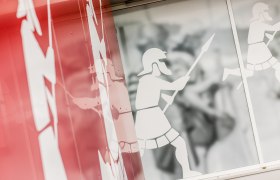 Grafik von römischen Soldaten auf einer Glaswand.